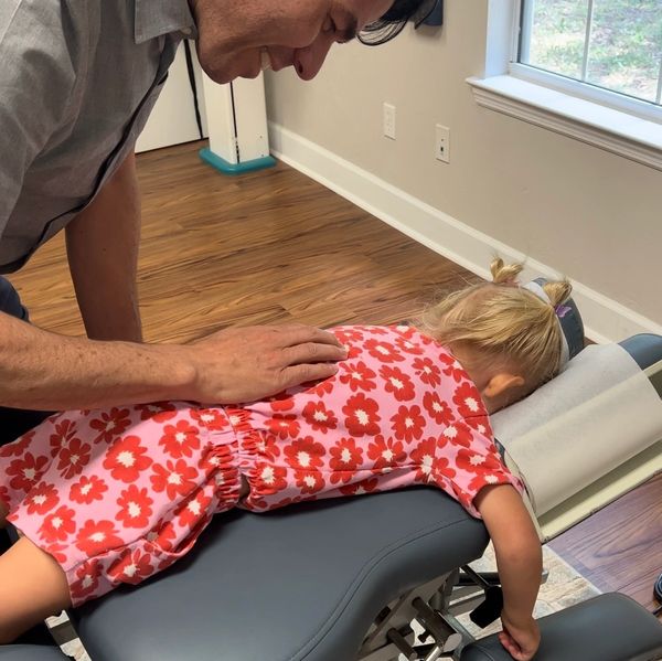 Dr. Powell adjusting a child